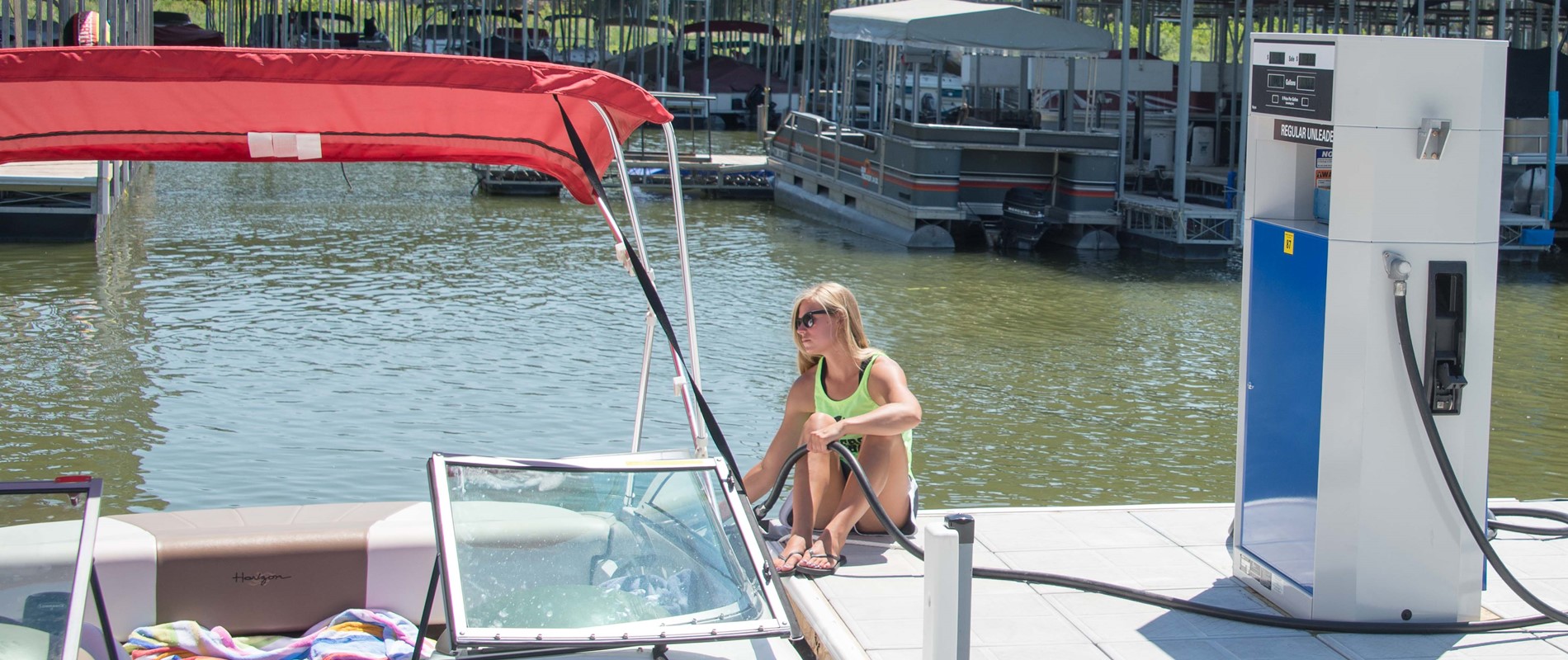 woman filling boat with gas on dock